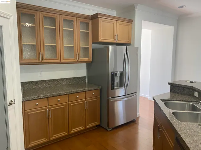 a kitchen with stainless steel appliances granite countertop a refrigerator and a sink
