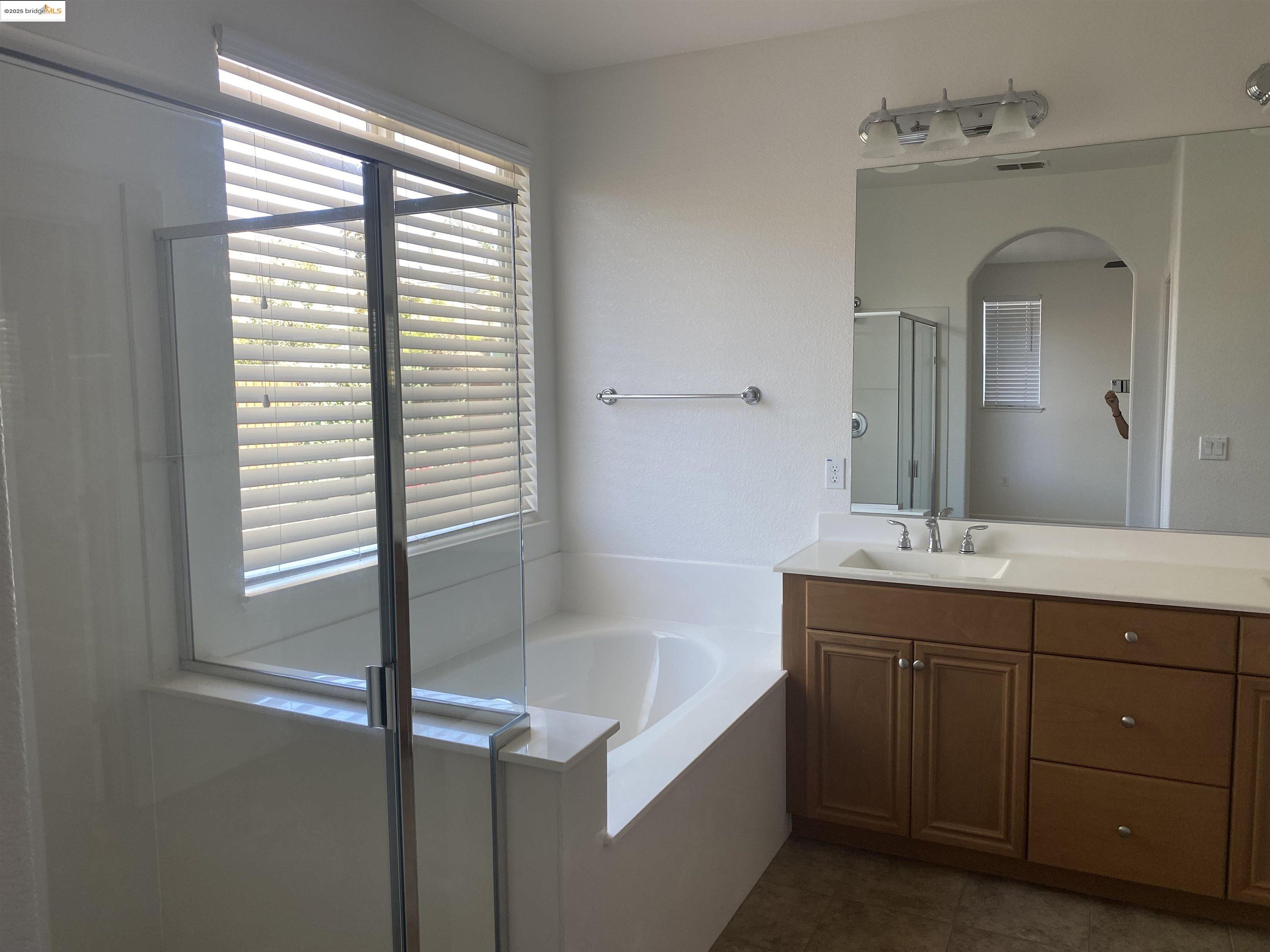 9821 Key W Way Discovery Bay, CA 94505 - Photo 8 of 14 a bathroom with a bathtub sink vanity and mirror