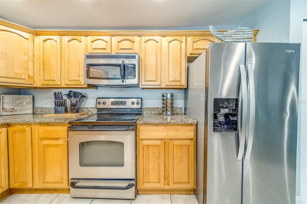 14414 91st Avenue North Seminole, FL 33776 - Photo 11 of 58 a kitchen with stainless steel appliances granite countertop a refrigerator and a stove top oven