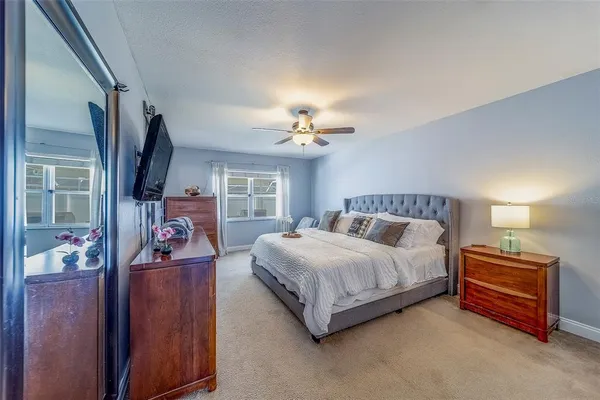 a bedroom with a bed and a flat tv screen on dresser