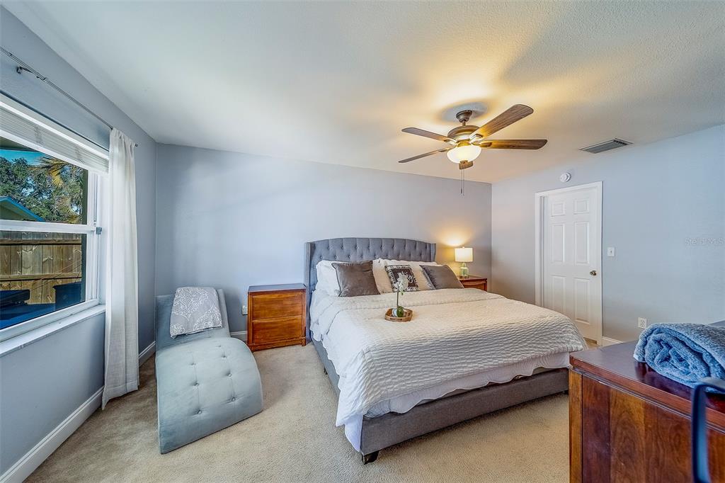 14414 91st Avenue North Seminole, FL 33776 - Photo 19 of 58 a bedroom with a bed and a chandelier