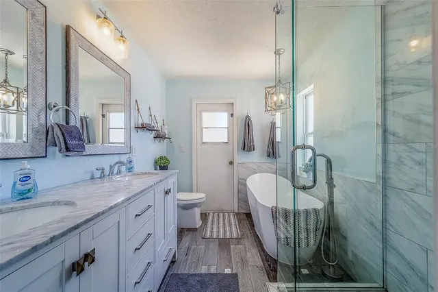 a bathroom with a granite countertop toilet sink and mirror