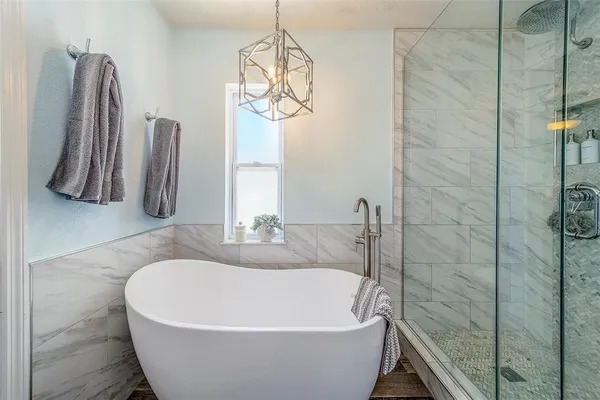 a bathroom with a granite countertop sink mirror and a bathtub