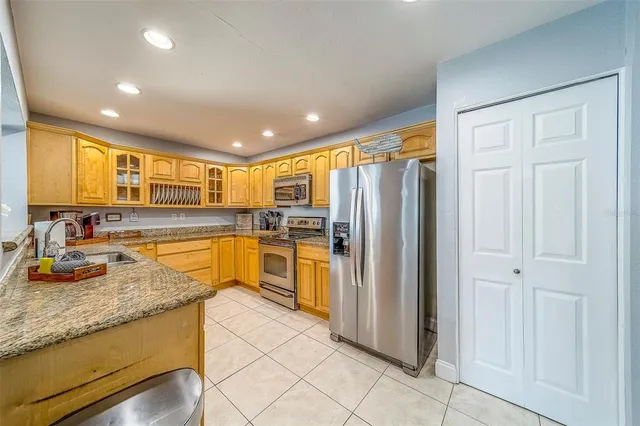 a kitchen with stainless steel appliances granite countertop a sink and cabinets with wooden floor
