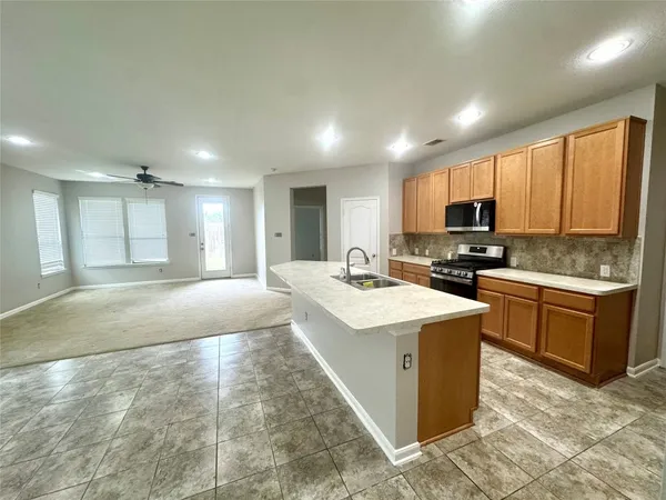 a large kitchen with kitchen island a sink stainless steel appliances and cabinets
