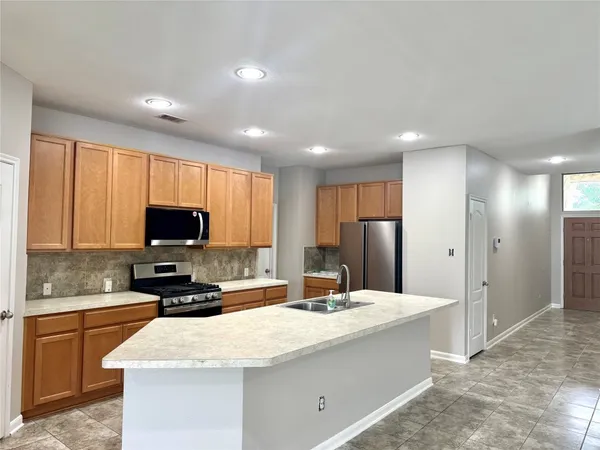 a kitchen with stainless steel appliances granite countertop a sink refrigerator and microwave