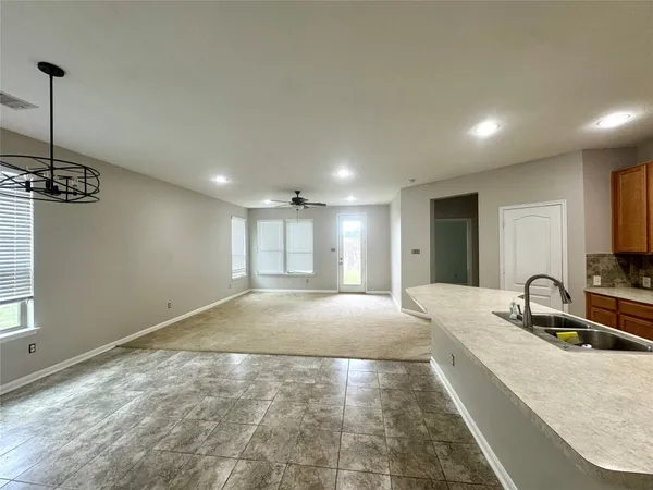 a large white kitchen with kitchen island a sink stainless steel appliances and a counter top space