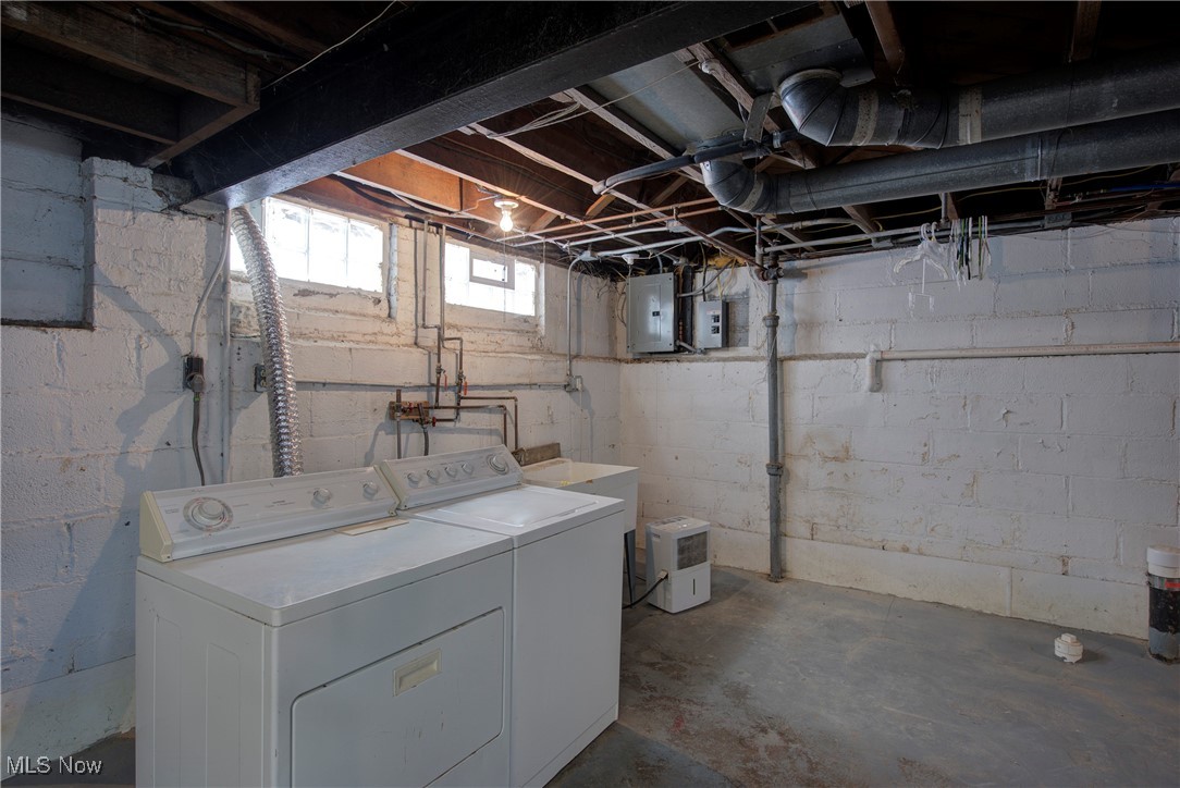 4041 Wilmington Road Cleveland, OH 44121 - Photo 33 of 38 Laundry room with concrete flooring, washing machine and clothes dryer, and electric panel