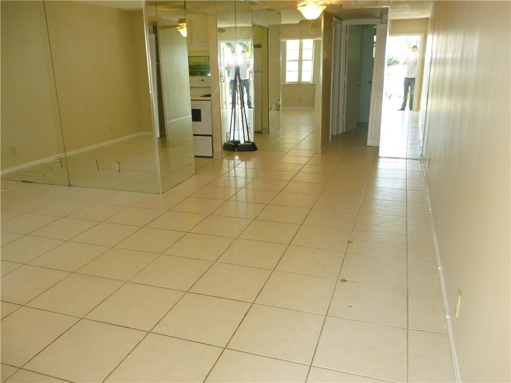 2131 Northeast 41st Street, Unit 107 Lighthouse Point, FL 33064 - Photo 14 of 18 a bathroom with a glass shower door