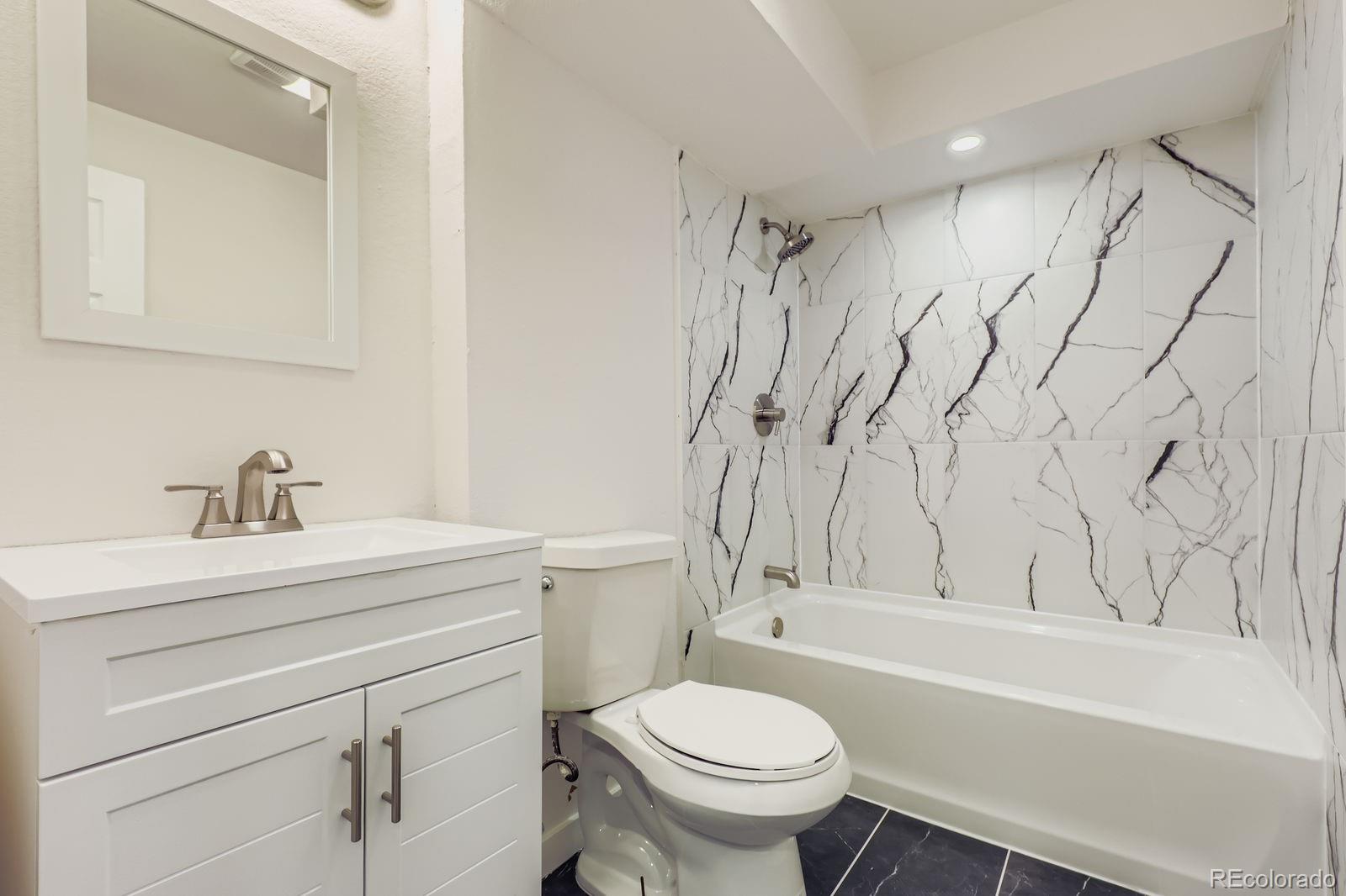 831 Sable Boulevard Aurora, CO 80011 - Photo 22 of 26 a bathroom with a sink toilet and shower