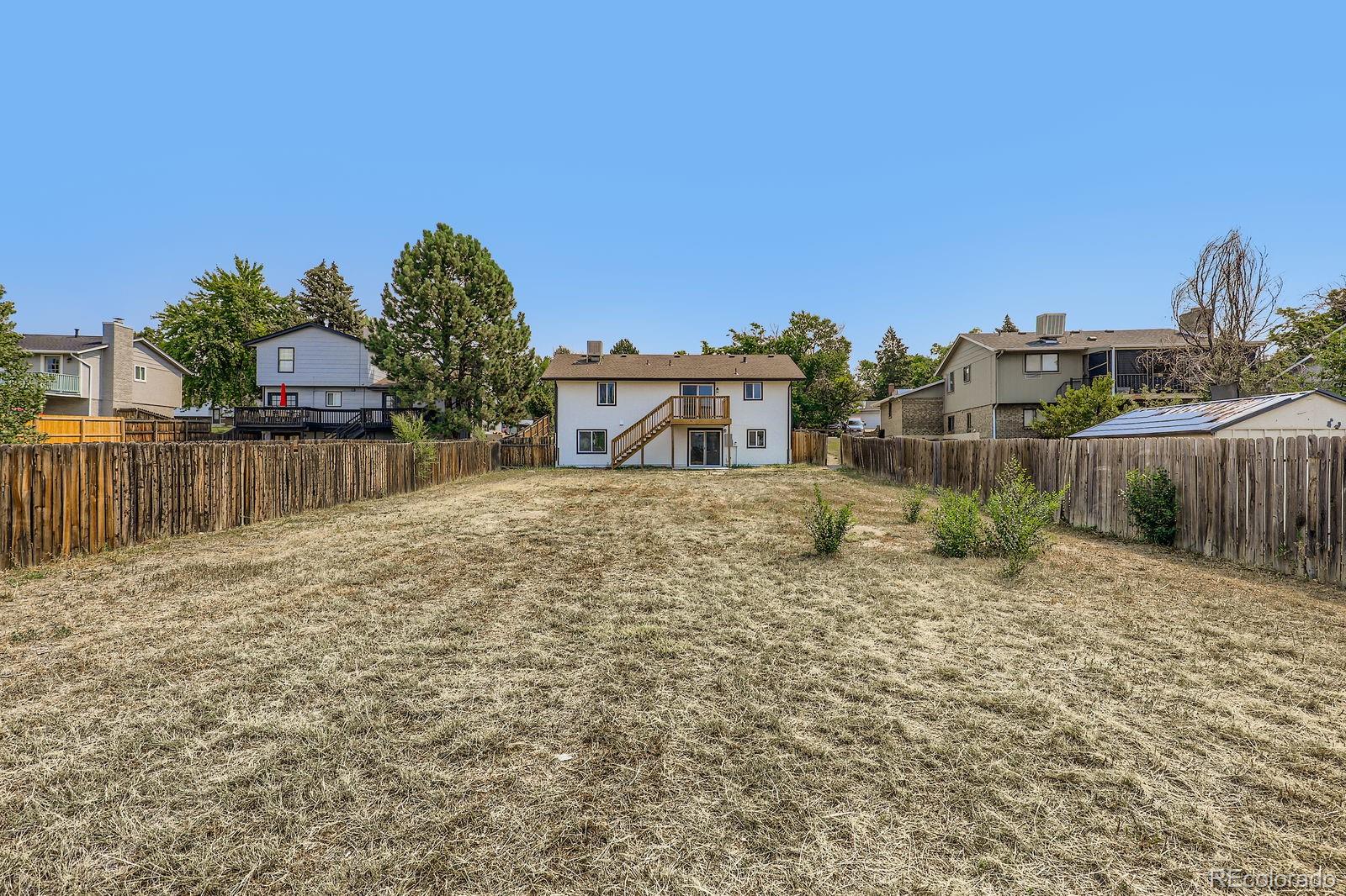 831 Sable Boulevard Aurora, CO 80011 - Photo 25 of 26 a pathway of a house with a yard and fence