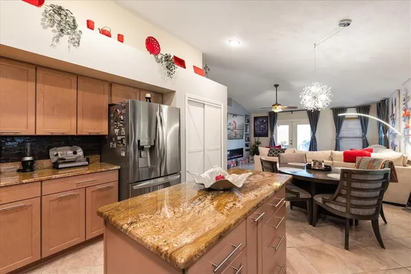 a kitchen with stainless steel appliances kitchen island granite countertop a sink dishwasher and cabinets with wooden floor