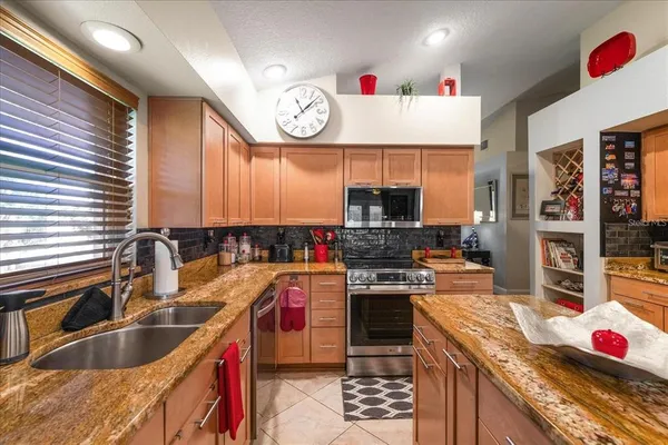 a kitchen with granite countertop a sink stove and cabinets