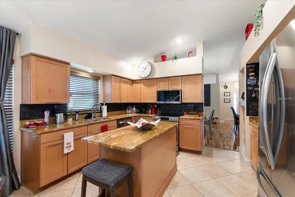 a kitchen with a refrigerator a sink dishwasher and a stove with wooden cabinets