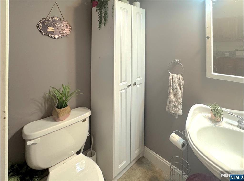 68 Washington Avenue Rutherford, NJ 07070 - Photo 12 of 23 a white toilet sitting next to a bathroom sink and a mirror