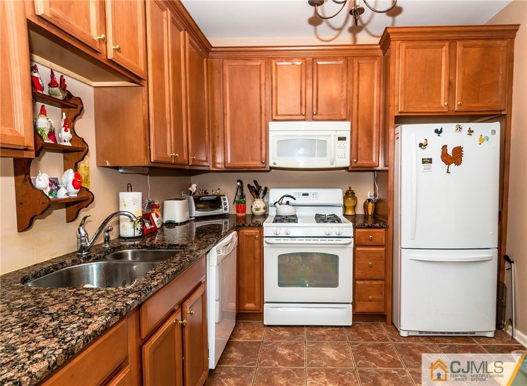 203 Potts Road Morganville, NJ 07751 - Photo 14 of 25 a kitchen with a refrigerator sink and cabinets