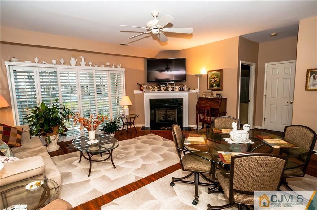 203 Potts Road Morganville, NJ 07751 - Photo 17 of 25 a living room with furniture a fireplace and a chandelier