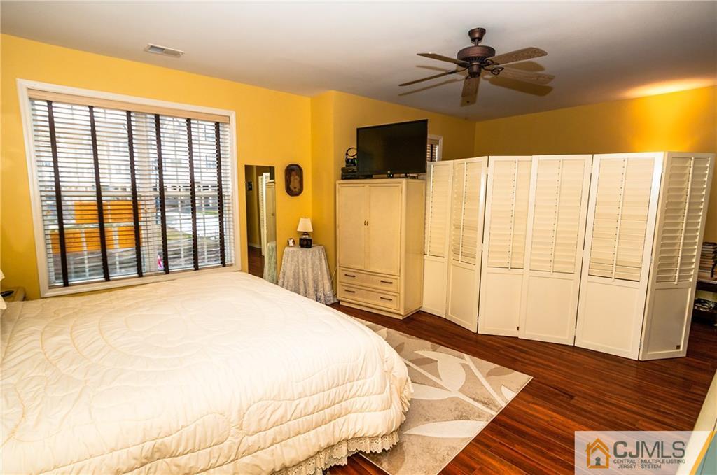 203 Potts Road Morganville, NJ 07751 - Photo 6 of 25 a bedroom with a large bed and a flat tv screen