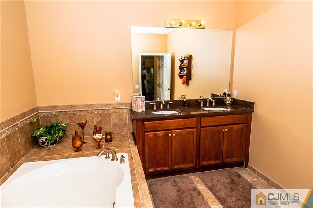 203 Potts Road Morganville, NJ 07751 - Photo 9 of 25 a bathroom with a sink and a mirror