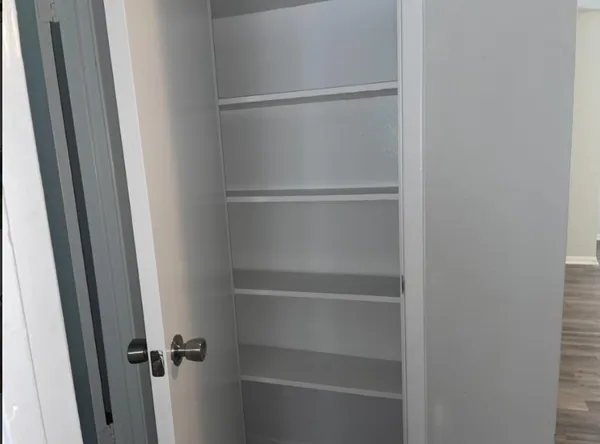 a view of walk in closet with empty racks