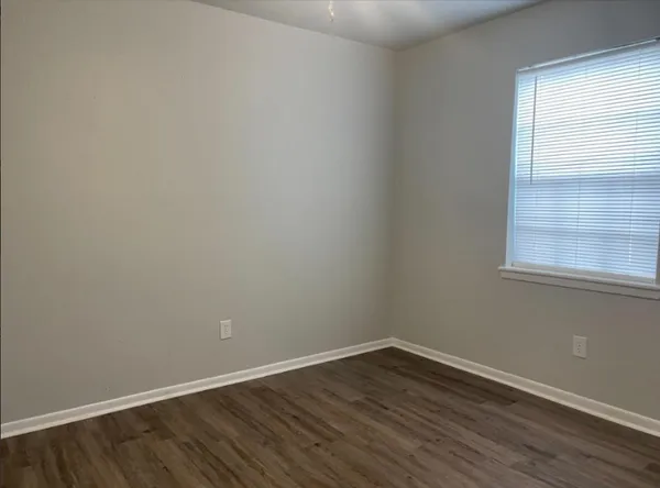 a view of a hallway with wooden floor and chandelier fan
