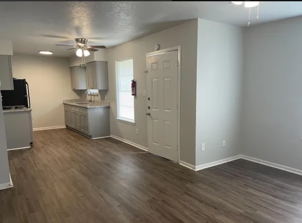a kitchen with granite countertop white cabinets and a sink