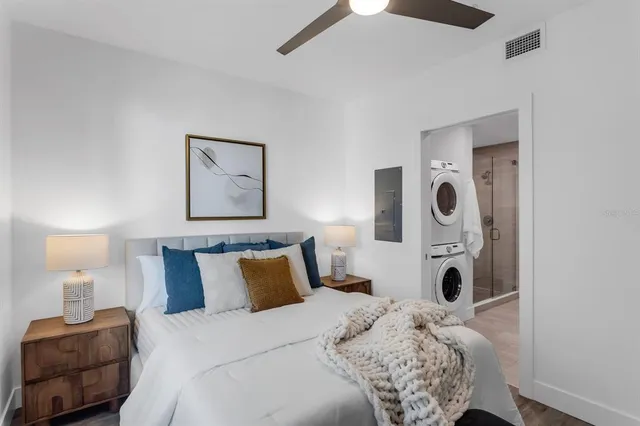 a bedroom with a bed and a potted plant