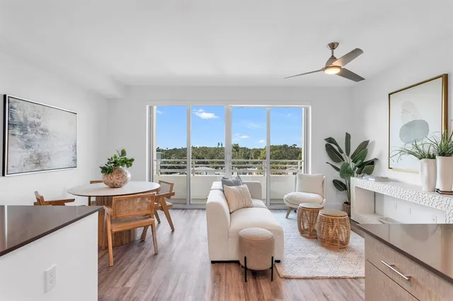 a living room with stainless steel appliances furniture and a kitchen view