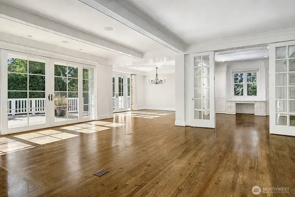 a view of empty room with wooden floor and floor to ceiling window