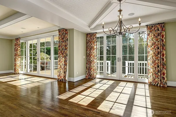 a view of empty room with wooden floor and floor to ceiling window