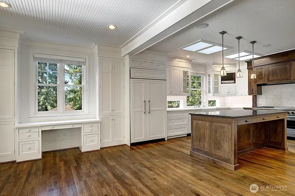 a kitchen with stainless steel appliances granite countertop a sink cabinets and wooden floor