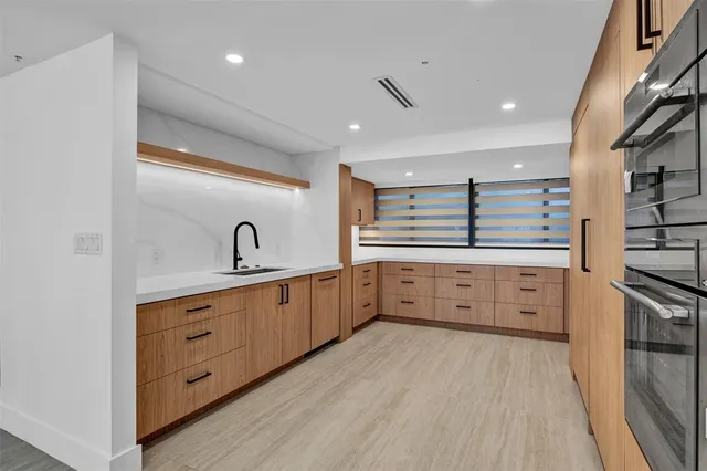 a large white kitchen with cabinets