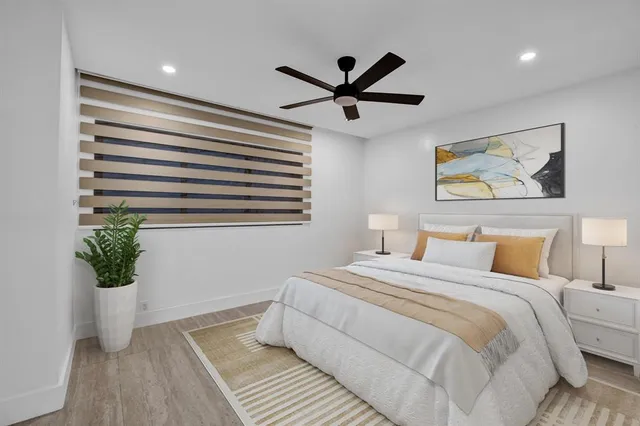 a bedroom with a large bed and a potted plant