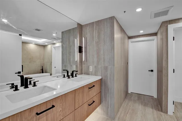 a bathroom with double vanity sink and a mirror