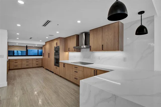 a kitchen with stainless steel appliances granite countertop a sink a stove and a refrigerator