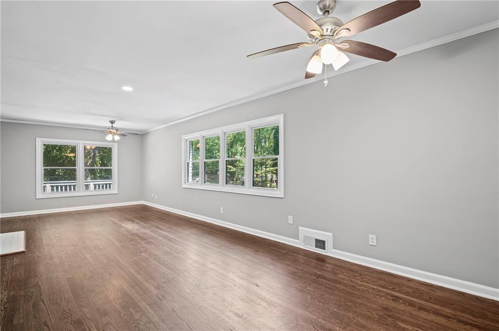 2790 Collier Drive Northwest Atlanta, GA 30318 - Photo 11 of 44 an empty room with wooden floor chandelier fan and windows