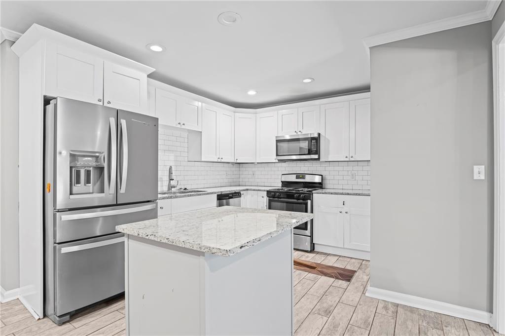 2790 Collier Drive Northwest Atlanta, GA 30318 - Photo 13 of 44 a kitchen with white cabinets and stainless steel appliances