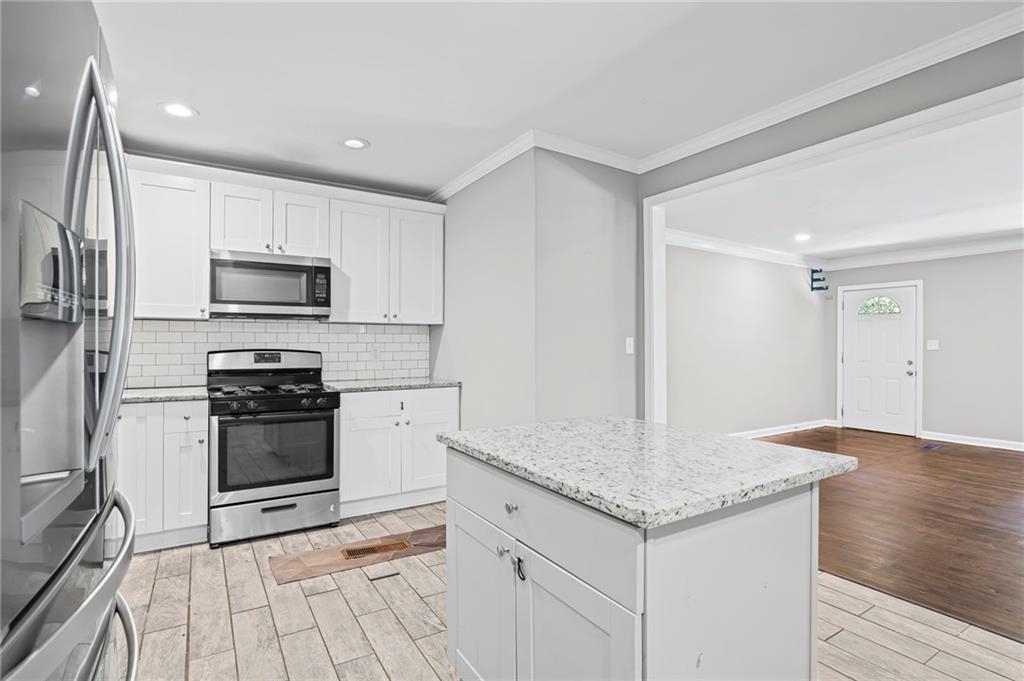 2790 Collier Drive Northwest Atlanta, GA 30318 - Photo 15 of 44 a kitchen with granite countertop a stove and a sink