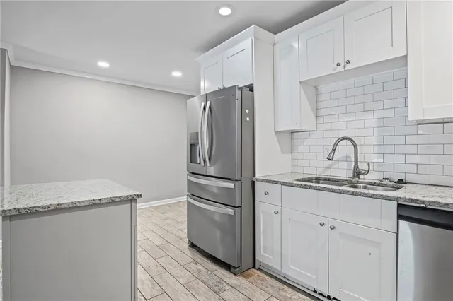 a kitchen with stainless steel appliances granite countertop a sink and a refrigerator