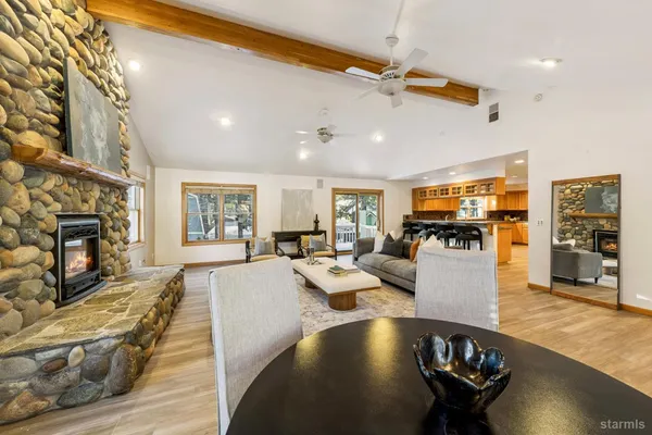 a large kitchen with kitchen island granite countertop a stove a sink dishwasher and white cabinets with wooden floor