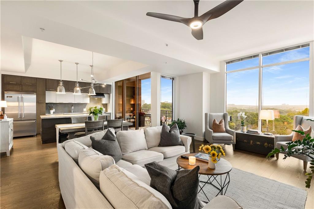 a living room with furniture kitchen view and a large window