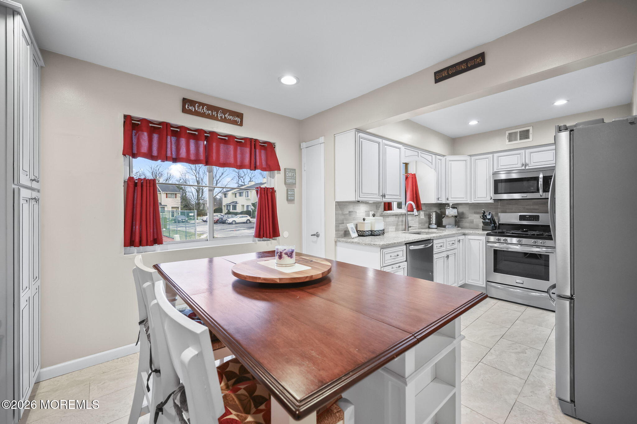 316 Middlewood Road Middletown, NJ 07748 - Photo 11 of 33 a kitchen with stainless steel appliances kitchen island granite countertop a stove a refrigerator a stove a dining table and chairs with wooden floor