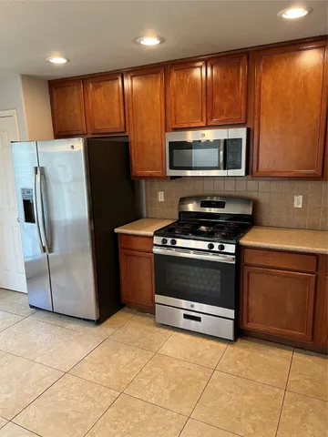 a kitchen with stainless steel appliances a stove a microwave and a refrigerator