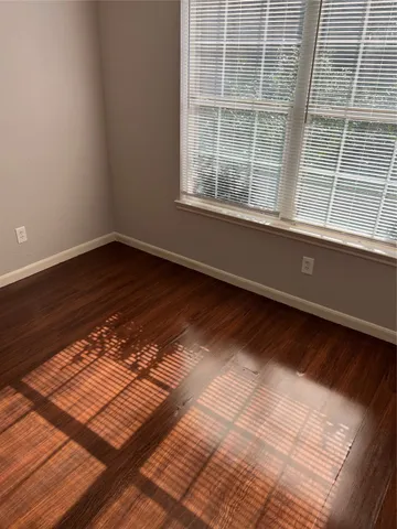 a view of a room with wooden floor and windows