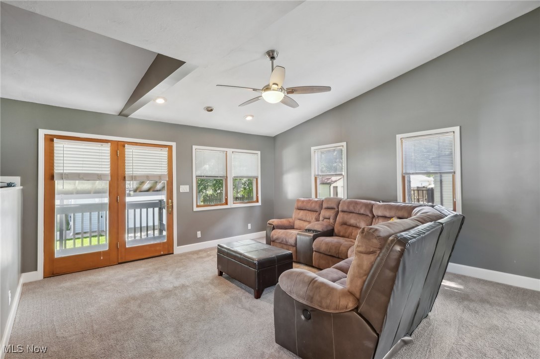 1567 Roselawn Road Cleveland, OH 44124 - Photo 12 of 29 Living room with ceiling fan, vaulted ceiling, a wealth of natural light, and light carpet