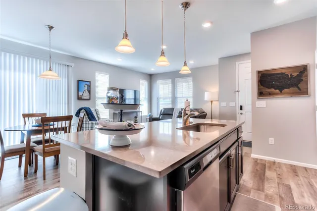 a kitchen with sink stove and a refrigerator with wooden floor