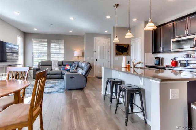 a living room with furniture a flat screen tv and kitchen view