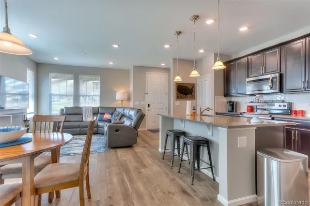 a living room with stainless steel appliances kitchen island granite countertop furniture and a wooden cabinets