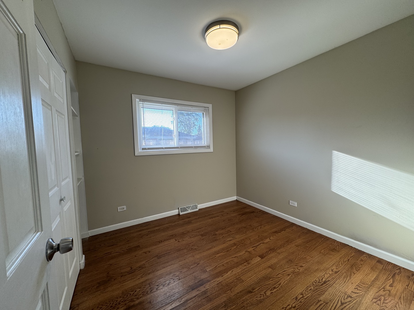 7838 West 73rd Place Bridgeview, IL 60455 - Photo 14 of 22 an empty room with wooden floor and windows