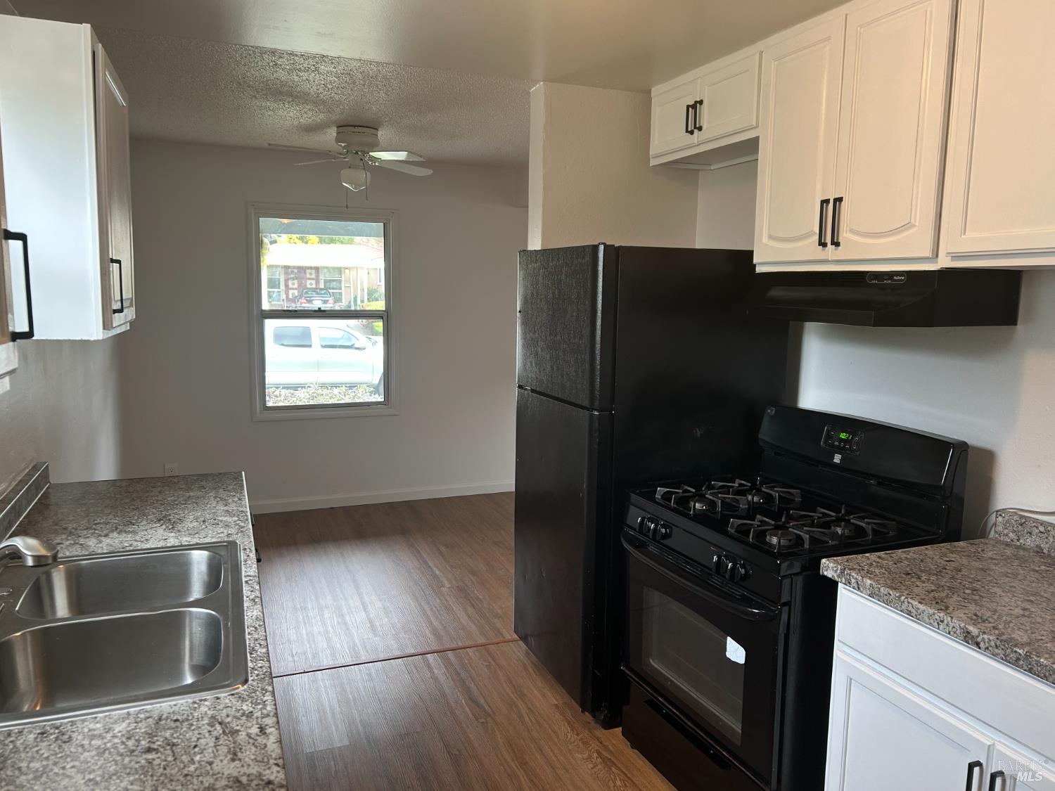 243 Sage Street Vallejo, CA 94589 - Photo 3 of 9 a kitchen with granite countertop a stove and a refrigerator
